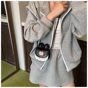 Détail de la broderie pomme et du nœud noir sur le mini sac à pois mignon
