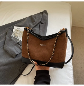 Detail of vintage matte suede and black leather patchwork bag with gold chain strap