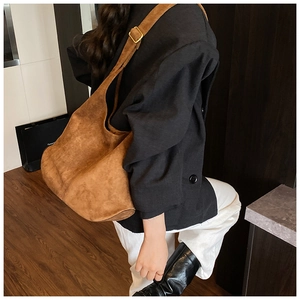 Detail of large brown suede hobo bag with adjustable strap and vintage gold buckle