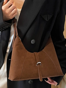 Brown suede crescent hobo shoulder bag styled with black blazer for a chic office look