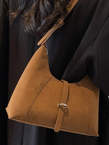 Brown suede crescent underarm bag with decorative leather strap and metal buckle