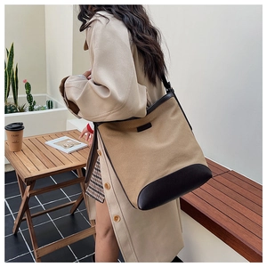 Detail of canvas and leather shoulder bag worn by model in a minimalist lifestyle setting