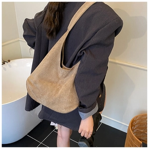 Brown suede hobo shoulder bag shown on model with a textured matte finish