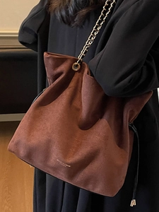Sac seau en daim marron avec cordon de serrage et bandoulière chaîne dorée élégante
