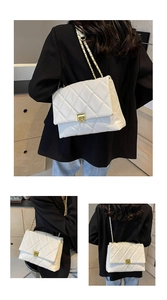 Detail of white quilted crossbody bag with golden chain strap and flip-top metal lock