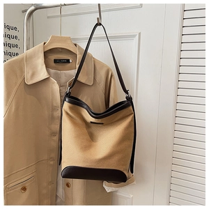 Chic canvas and leather hobo bag hanging on a trench coat with minimalist aesthetic