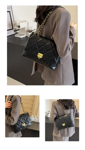 Black quilted crossbody bag with gold chain and metal lock for office commute