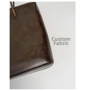 Close-up of premium dark brown vintage leather texture and side stitching on tote bag