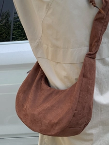 Retro tan faux suede hobo bag with drawstring design shown as crossbody style on model