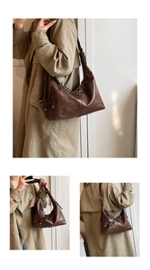 Detail of retro dark brown leather hobo bag featuring dog pendant and woven strap details