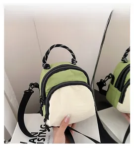 Detail of color-block mini backpack with green and white fabric and black woven handle