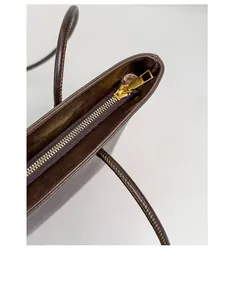 Detail of premium golden metal zipper and stitching on the brown leather tote bag