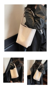 Détail d'un sac seau minimaliste en cuir beige avec une longue bandoulière pour femme