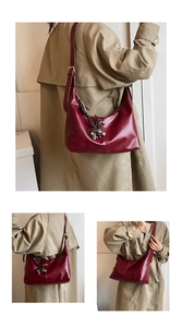 Detail of burgundy leather hobo bag with adjustable strap and horse charm on model