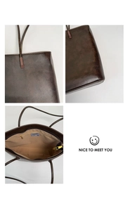 Detailed interior of vintage brown tote bag showing metal zipper pocket and roomy lining