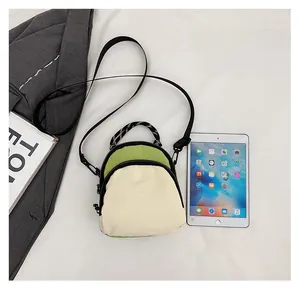 Mini nylon crossbody bag size comparison with tablet showing practical dimensions