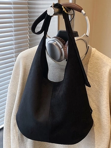 Minimalist black matte hobo shoulder bag with vertical seam detail and wide strap