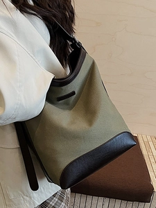 Olive green canvas and dark brown leather bucket shoulder bag in a retro style