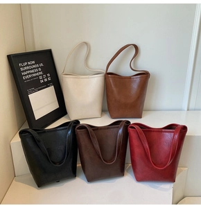 Détail de cinq sacs cabas minimalistes en blanc, kaki, noir, marron et rouge