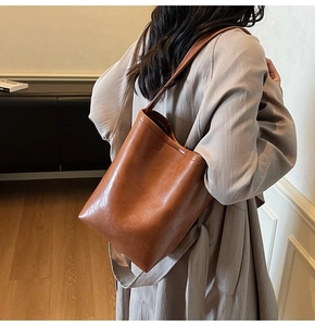 Sac fourre-tout en cuir marron porté par un mannequin montrant sa grande capacité