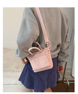 Pink multi-functional nylon tote bag shown with model in a home setting