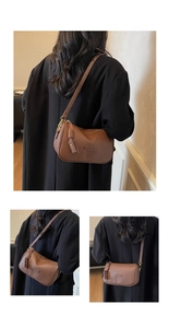 Détail du sac Boston en cuir grainé marron vintage avec logo et fermeture éclair à glands