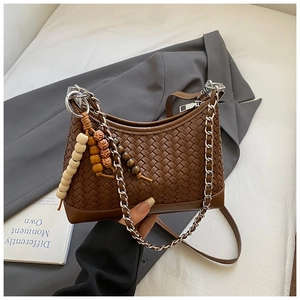 Detail of dark brown woven pillow bag with silver chain and colorful wooden bead decor