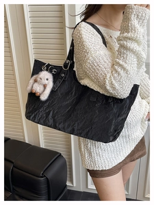 Détail du sac cabas noir avec texture froissée et pendentif lapin en peluche blanc