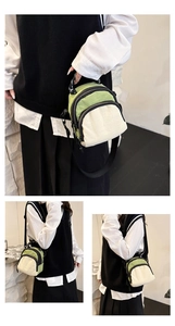 Detail view of mini nylon crossbody bag featuring green and white color-block and zippers
