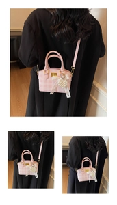 Close-up of pink and white checkered mini handbag with lace bow and pearl heart charm