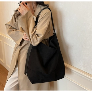 Détail du sac seau en daim noir montrant la grande capacité et la boucle en métal argenté