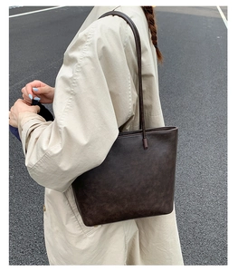 Street style view of a vintage dark brown tote bag paired with a beige trench coat