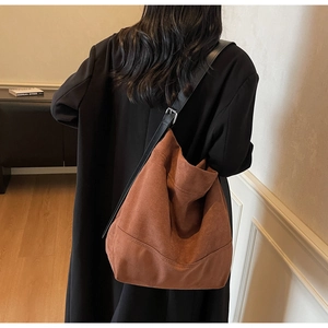 Sac seau en daim caramel avec bandoulière réglable porté par un mannequin