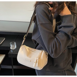 Gros plan du sac Boston crème en cuir grainé lychee avec plaque en métal fashion