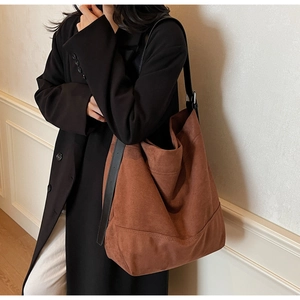 Détail d'un grand sac hobo en daim marron montrant sa texture douce et sa boucle en métal