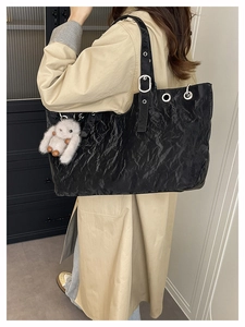 Détail du sac cabas en similicuir noir plissé avec œillets et charm lapin en peluche