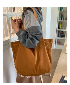 Vue détaillée d'un grand sac cabas en toile ocre porté par un mannequin pour le quotidien