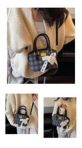 Detail of vintage plaid handbag with gold twist lock and a pearl heart lace charm