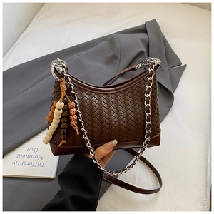 Close-up of dark brown woven shoulder bag featuring silver chain and colorful wooden beads