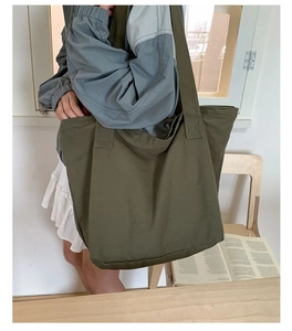 Détail du grand sac cabas en toile vert olive avec coutures renforcées et larges anses