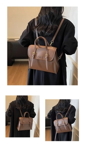 Detailed view of brown vintage leather backpack with adjustable gold buckles and flap design