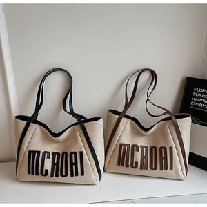 Détail du grand sac cabas en toile avec garniture en cuir et logo MCROAI brodé