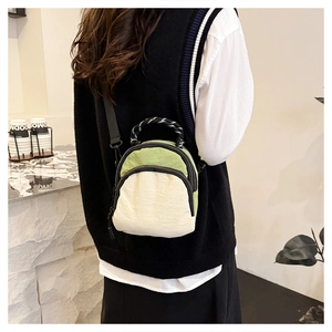 Detail of nylon mini crossbody bag showing dual zippers and braided handle texture