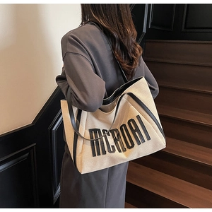 Détail du sac fourre-tout en toile avec imprimé MCHDAI et bordure en cuir noir élégant
