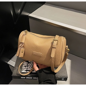 Détail de la texture en cuir litchi et de la fermeture éclair en métal doré du sac