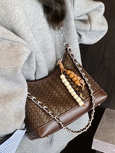 Brown woven crossbody pillow bag with silver chain strap and colorful bead charm