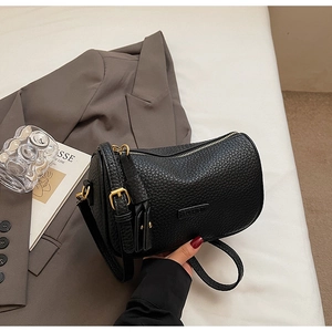 Détail du sac Boston en cuir noir à motif litchi avec finitions métalliques dorées chic