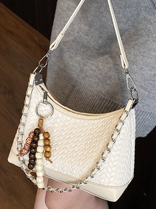 White woven pillow bag with silver chain and beaded charm in a minimalist Korean style