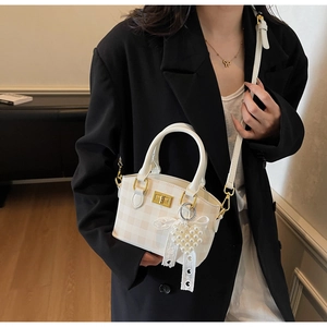 Detail of checkered mini crossbody bag with pearl heart pendant and golden twist lock