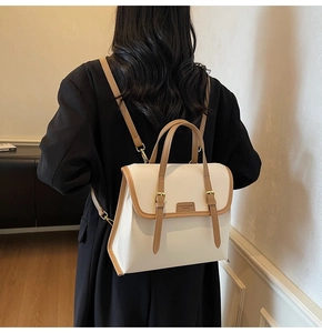 Detail showing the dual-use brown and white leather backpack with adjustable straps